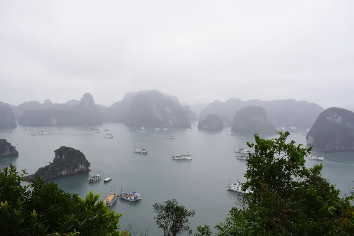 View over karst islands and boats from the top of Ti Top Island on a Ha Long Bay junk boat cruise